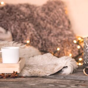 still-life-home-atmosphere-interior-with-cups-candles-table-cozy-bedspreads_169016-1307